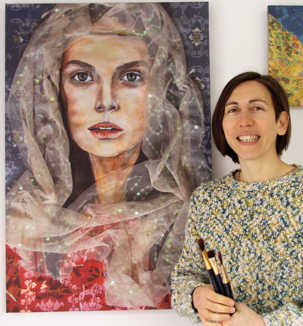 Natalie Dekel next to a canvas print of her painting ‘Esther’. (Photo by Gil Dekel, 2022).